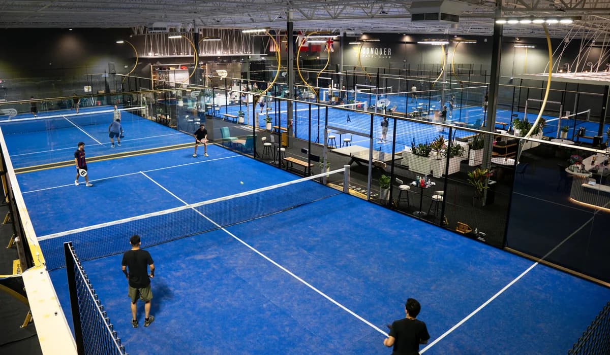 Players on blue indoor padel courts at Conquer Padel Tempe.
